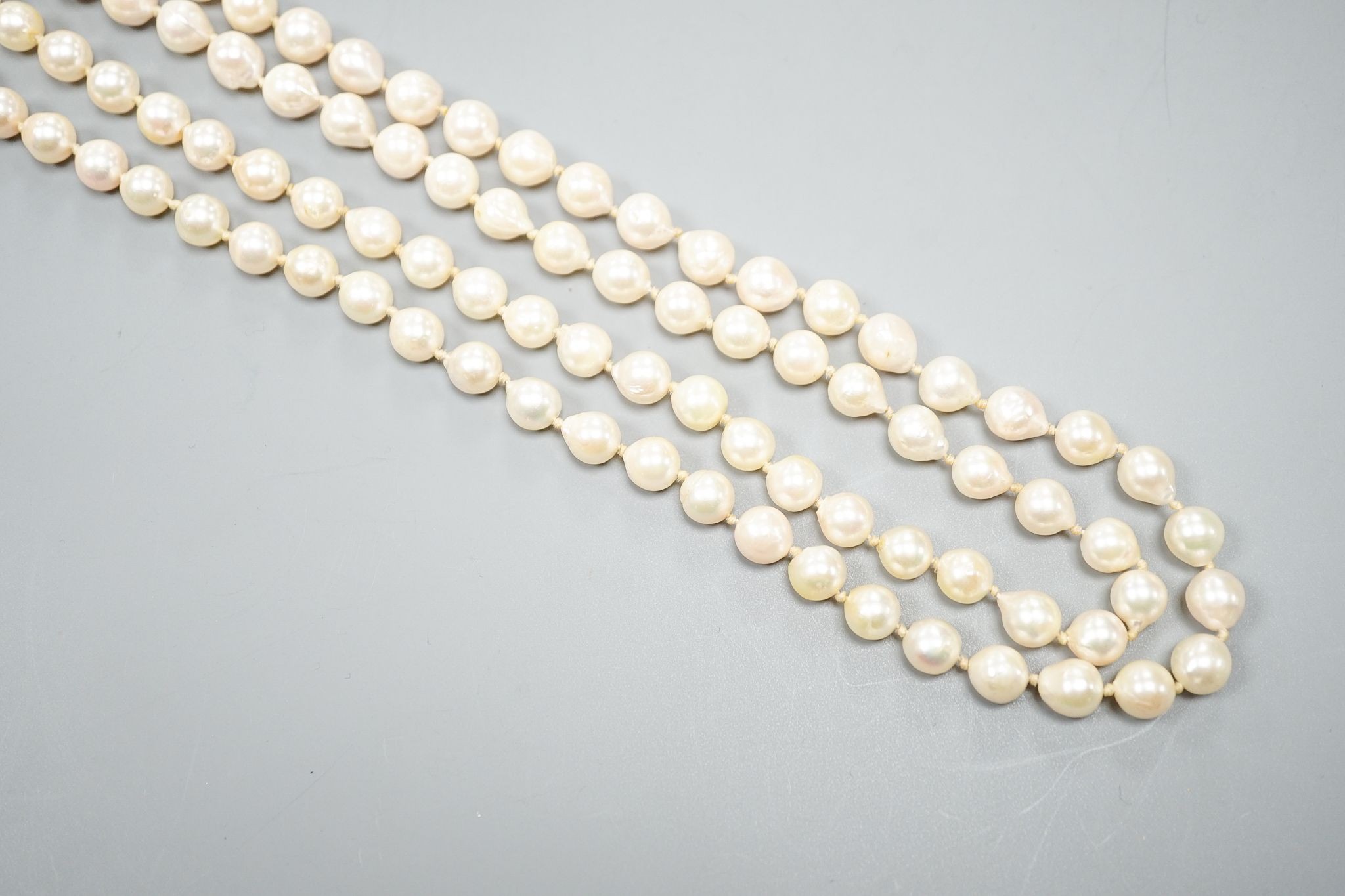 A modern long single strand cultured pearl necklace, with fluted 14k and diamond chip set clasp, 116cm.